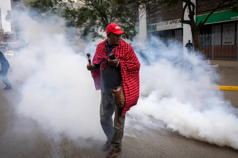 A man is surrounded by tear gas thrown by police during a Maasai rights demonstration outside the Tanzanian high commission in downtown Nairobi, Kenya, on June 17, 2022. Ben Curtis / AP Photo