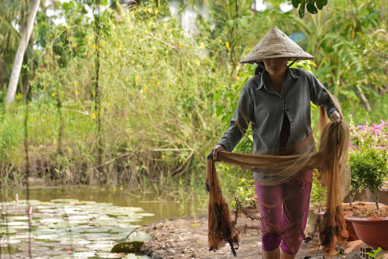 A farmer carries a net.