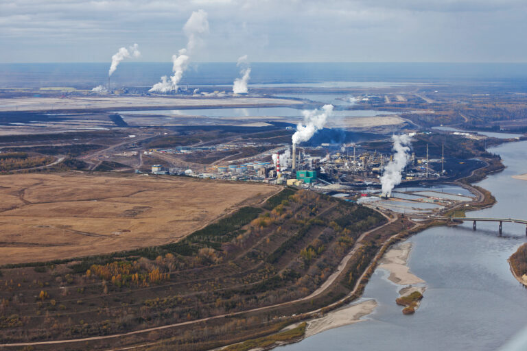 Oil refinery smokestacks along the Athabasca River, in northern Alberta, Canada.