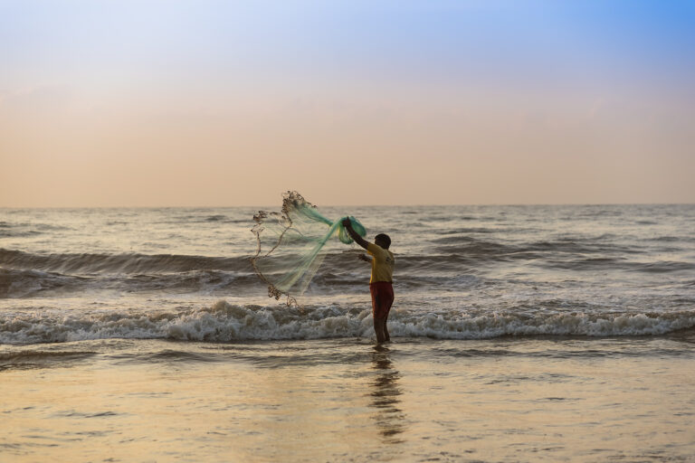 A fisherman casts his net at a beach in Chennai, India.