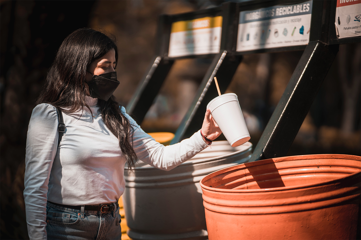 A woman throws out a styrofoam cup in Mexico City. 