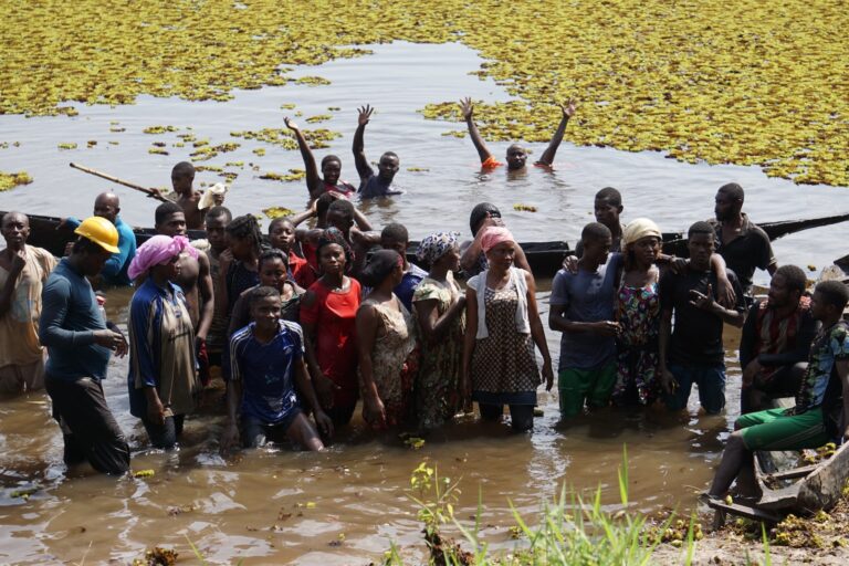 Community members at Lake Ossa in Cameroon help fight the invasive aquatic fern, the giant salvinia (Salvinia molesta). (Credit: African Marine Mammal Conservation Organization).