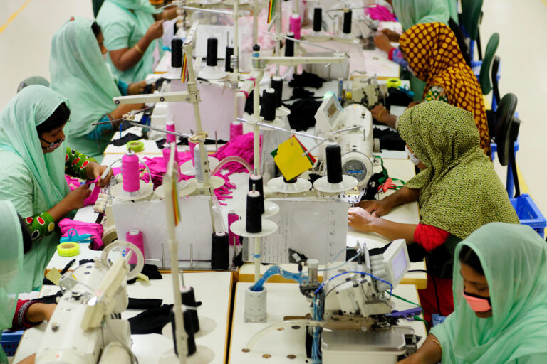 Tailors are seen working on a production line in a local garment factory in Bangladesh.