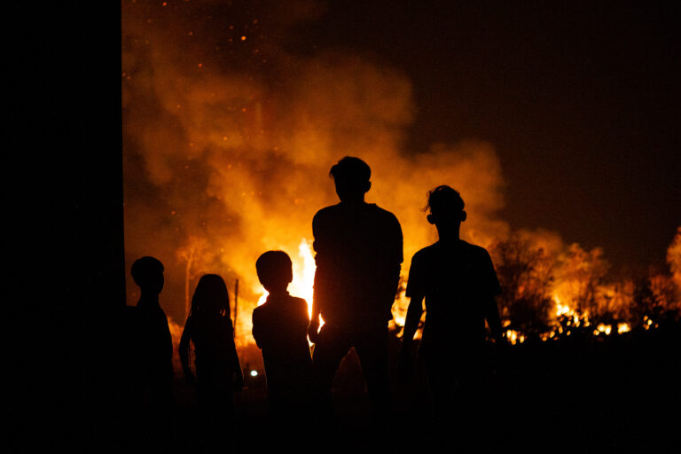 People watch a forest fire in Kratié Province, Cambodia.