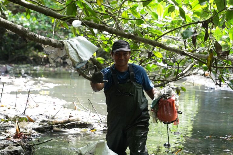 Volunteers clearing plastic trash gathered from river barriers. Image courtesy of Sam Benchegjib.