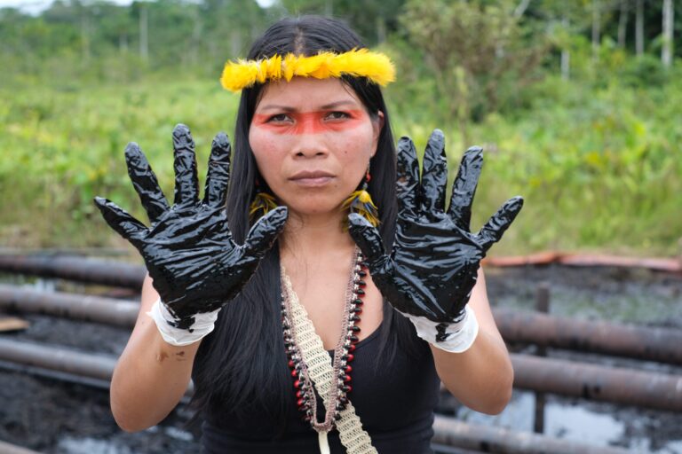 Nemonte Nenquimo stands alongside an oil spill near Shushufindi in the province of Sucumbíos, Ecuadorian Amazon, June 26th 2023. Image by Sophie Pinchetti / Amazon Frontlines.