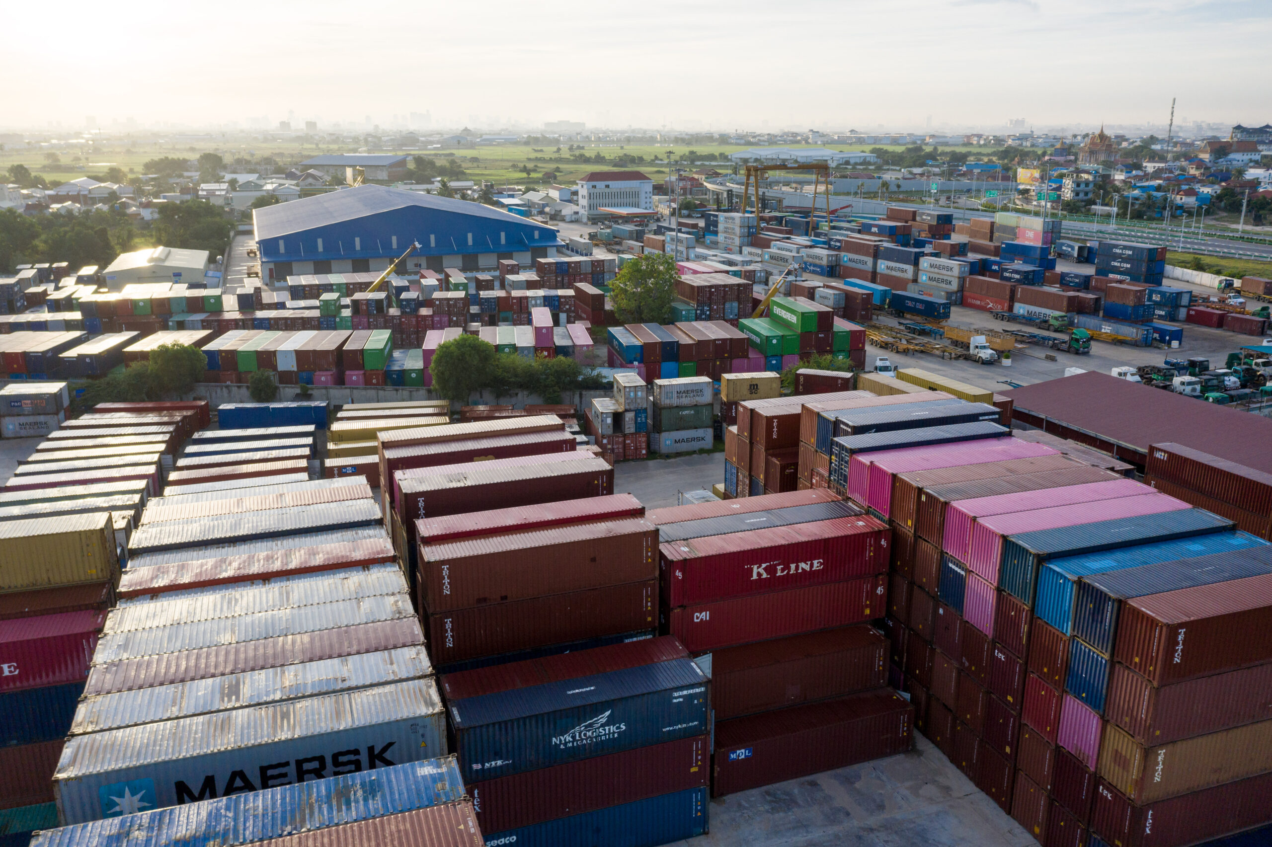 An aerial view of one of more than 20 dry ports scattered across Cambodia that store and transport goods for import and export, including garments. Of an estimated 680 factories producing garments, footwear, and travel goods across Cambodia, they generated for export $11.3 billion in 2021 and $12.6 billion in 2022. Credit: Andy Ball/Mongabay.