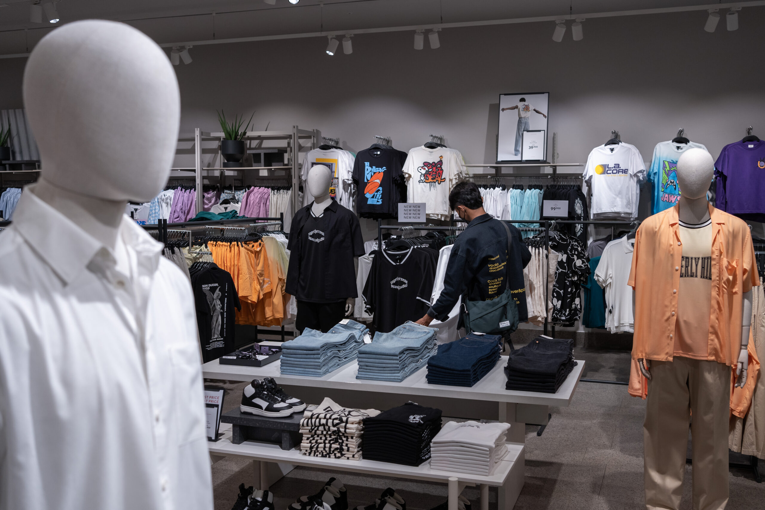 A customer looks through the selection of clothes at H&M’s flagship store in the Aeon 1 shopping mall, Phnom Penh. Four factories supplying to the Swedish conglomerate fashion brand were reported to be burning forest wood in a 2021 study by researchers at Royal Holloway, University of London. Credit: Andy Ball/Mongabay.