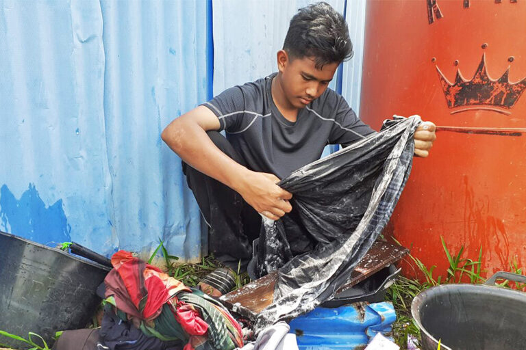 Muhammad Erlangga, a student, washes his clothes with rainwater.