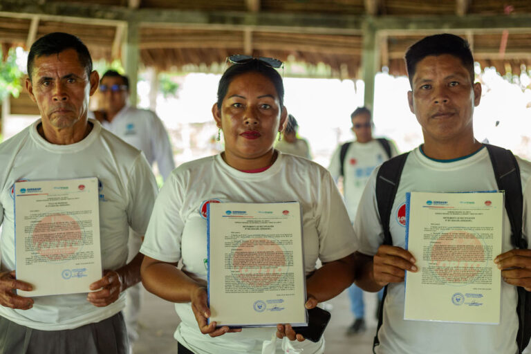 Holding their communities' titles are Apu Juan Jarana Pérez from San Alberto de Morona community, Apa Elizethy Cruz Ponciano from San Jose de Yanayacu community, and Pedro Alcidez Pérez Peña from Sargento Lores de Camote Isla community. Image courtesy of Sacha Cine/Rainforest Foundation US.