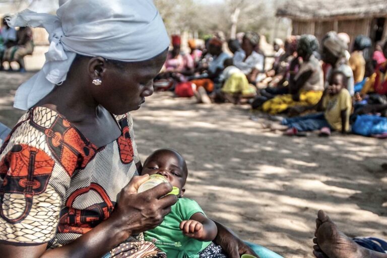 Mothers and children wait in Changanine community (Chibuto District), Mozambique to collect their seeds from the Red Cross. The community has been hit very hard by the current drought, many have lost their crops and locals have to walk up to five kilometres to dig for water. Image by Aurélie Marrier d'Unienville / IFRC via Flickr (CC BY-NC-ND 2.0).