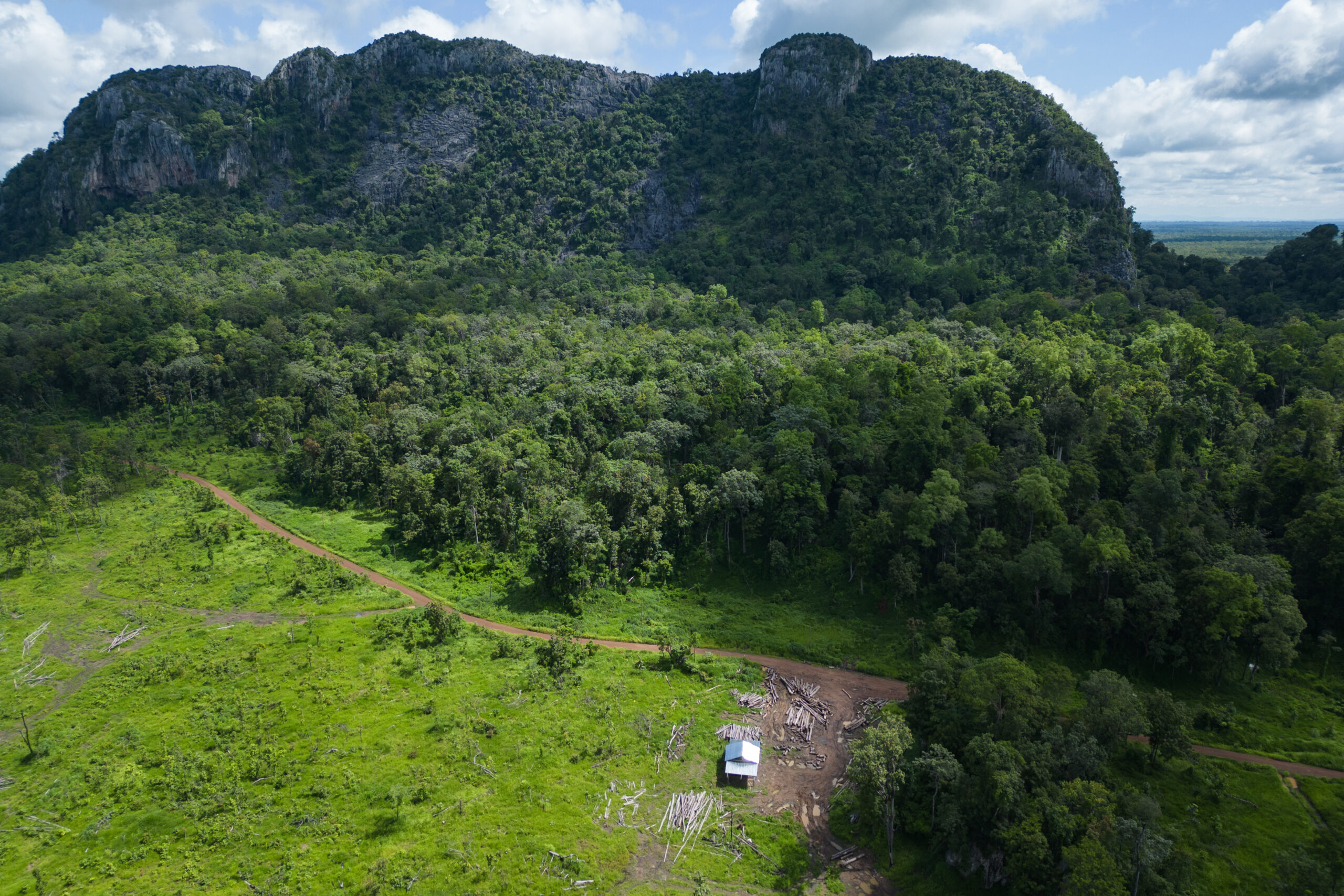 Overlooking the remaining forest in Phnom Chum Rok Sat sits a small timber depot with recently logged timber scattered about outside. Image by Gerald Flynn / Mongabay.